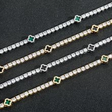 Close-up of gold and silver clover bracelets with green and black inlaid stones