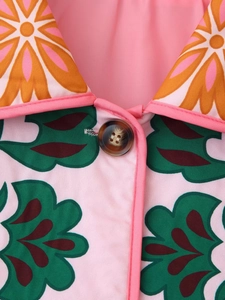 Detailed close-up of floral print cotton jacket with tortoise shell button and retro collar