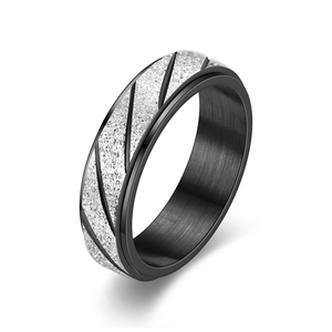 Macro detail of rotating titanium steel ring featuring silver frosted stripes and black inner band