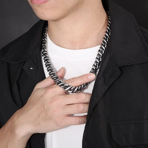Close-up of a men's vintage silver infinity Cuban link chain necklace on model