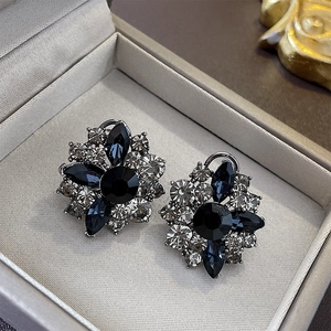 Detail of vintage flower stud earrings with black and clear crystals in a jewelry box