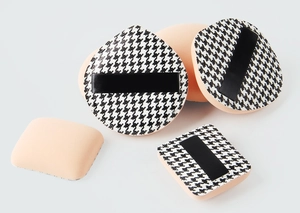 Detail of houndstooth makeup puffs in square and teardrop shapes with ribbon handles