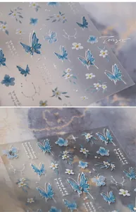 Detailed macro view of 5D embossed blue butterfly nail art stickers with floral patterns