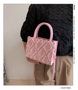 Detail of pink quilted plush tote bag showing soft texture and sturdy top handles
