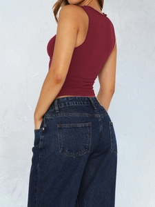 Rückansicht einer Frau in einem Y2K burgunderroten ärmellosen Top und blauen Jeans