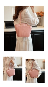 Detailed view of pink pleated PU shoulder bag with gold hardware on a model