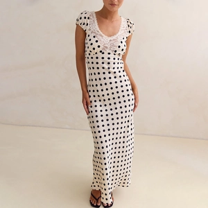 Detailed view of the V-neckline featuring intricate white lace stitching on satin polka dot dress