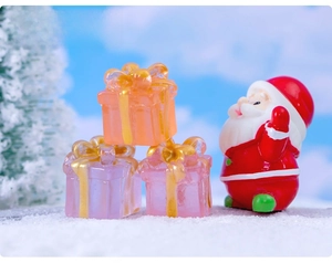 Miniature resin Santa Claus and colorful gift boxes in a snowy landscape detail