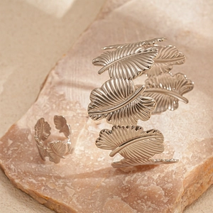 Detail of silver textured leaf open cuff bracelet and matching ring set on stone