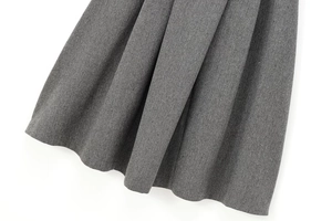 Close-up of grey herringbone fabric texture and weaving detail on blazer and skirt