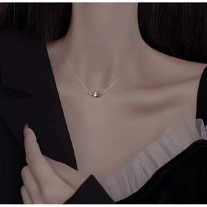 Close-up of a silver S925 sterling silver peace bird pendant on a model's neck