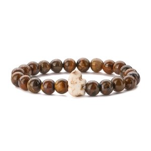Natural tiger eye beaded bracelet with a white textured stone elephant charm on white background
