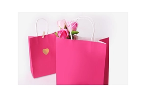 Detail of rose red paper gift bags with serrated edges and golden heart stickers
