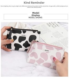 Close-up of slim cow print wallets with Milk label and smooth metal zipper details