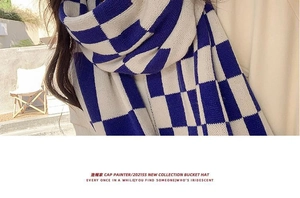 Detail of blue and white checkered knit scarf showing soft wool texture and warm weave