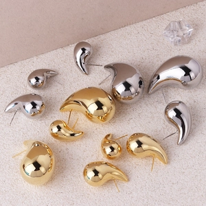 Macro shot of polished gold and silver teardrop earrings in various sizes for display