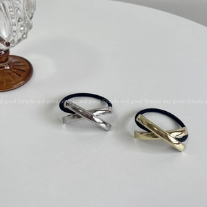 Macro view of metallic knot hair ties in polished gold and silver on a white background