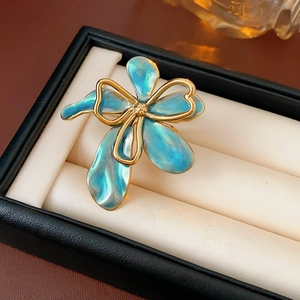 Detail of vintage flower brooch with gold metal lines and gradient blue glazed petals