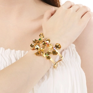 Detailed shot of a gold-toned flower cuff bracelet with vibrant multi-color gemstones