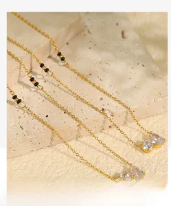 Detailed macro view of gold necklace with double zircon pendants on stone