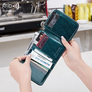 Deep teal blue RFID blocking leather wallet with multiple card slots held in a cafe setting