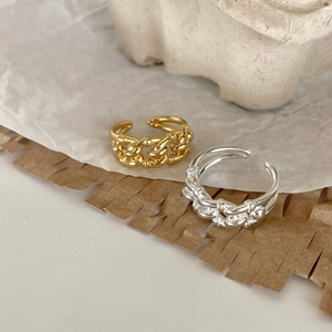 Golden and silver woven chain open rings made of 925 sterling silver on stone base