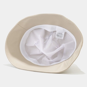 Beige PU leather bucket hat with adjustable inner drawstring and white fabric lining
