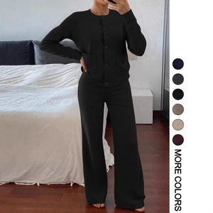 Détail d'un ensemble en maille noire avec cardigan boutonné et pantalon large