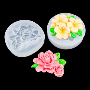 Detail view of rose and lotus silicone molds with finished pink and yellow floral soap crafts