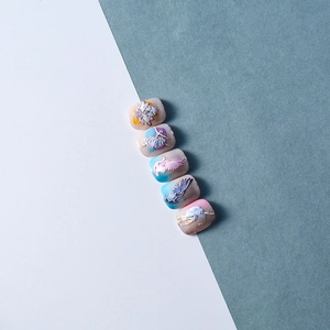 Macro detail of 3D embossed nail art featuring ballet dancer and floral relief designs