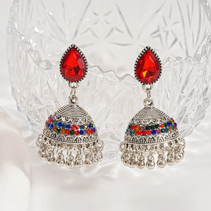 Detail of vintage ethnic Jhumka earrings with red teardrop stones and rainbow crystals