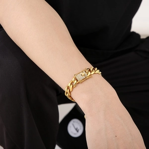 Close-up of gold-plated Cuban link chain featuring a square iced-out diamond clasp