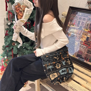 Detail of plush patchwork tote bag with geometric pattern in a cozy indoor setting