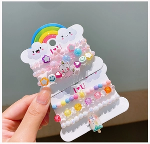 Detail showing colorful acrylic beaded bracelets with rainbow and cat charms for girls