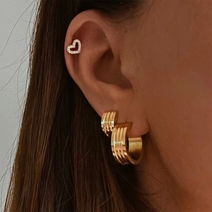 18K gold ribbed hoop earrings and heart diamond stud set on woman's ear