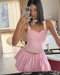 Detail of pink and white striped y2k halter top and pleated skirt in a mirror selfie