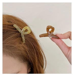 Close-up of translucent jelly-colored hair claws in yellow and amber on hair
