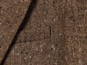 Macro shot of brown herringbone tweed fabric texture with subtle colorful fiber details