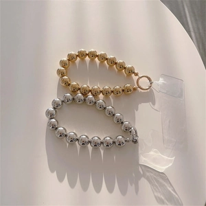 Polished gold and silver metallic ball wrist straps with secure round clasps and clear tabs