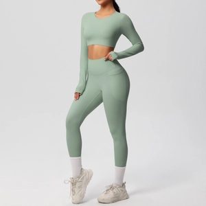 Detail of high-waist yoga leggings featuring a functional side pocket in sage green