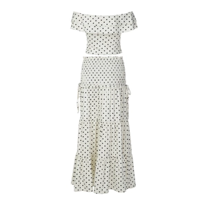 Detailed view of white polka dot crop top with ruffles and high-waist smocked skirt details