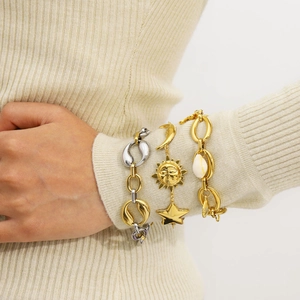 Chic layered gold bracelets featuring star, moon, and shell charms on model