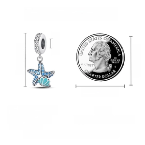 Detailed size view of silver starfish and blue shell charm with coin for scale
