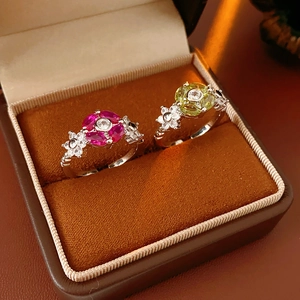 Detail of flower rings with pink and yellow zircons on a brown velvet jewelry box