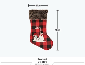 Détail de chaussette de Noël à carreaux rouges avec broderie Joy et bordure en fourrure