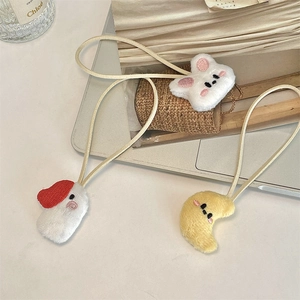 Detailed view of plush rabbit and monster charms with delicate embroidery and long cords