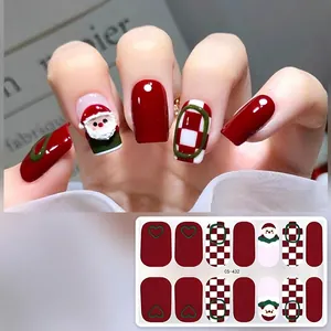Detailed view of Christmas gel nail stickers with Santa Claus and red checkered patterns