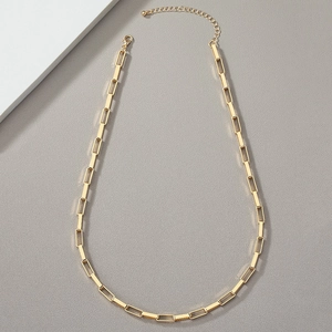 Detailed close-up of a minimalist gold geometric chain necklace with rectangular links