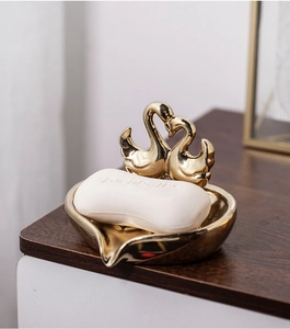 Detailed view of luxury golden swan soap dish on wood countertop for home decor