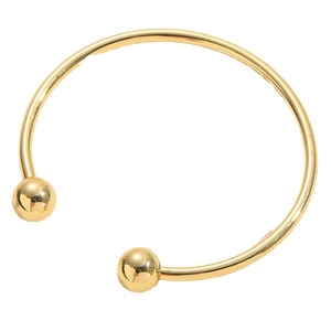 Bracelet jonc ouvert doré minimaliste avec deux sphères métalliques sur fond blanc